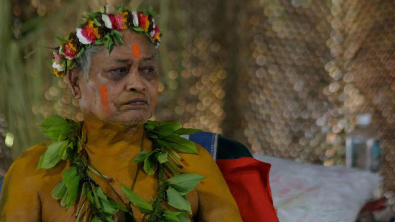 Papa Mau wears traditional lei and face paint